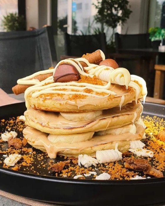 Pancakes with caramel, cream and biscuit crumb, out on the terrace.